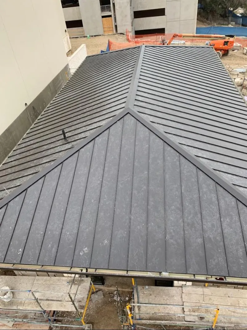 Commercial metal roof construction with crane equipment in Lincoln